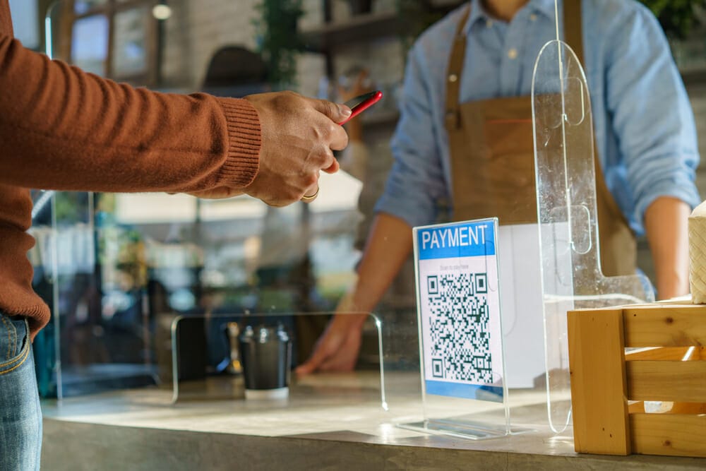 Man scanning a QR code to pay online using his phone