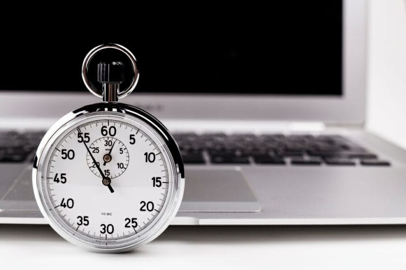 Image of a stopwatch in front of a laptop