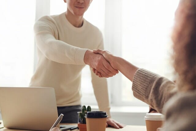 A man holding the hand of a woman after explaining their patient referral program