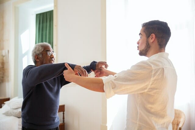 Physical therapist helping a patient to walk