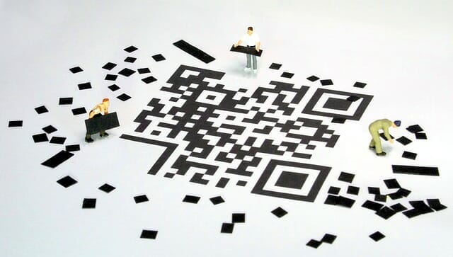 Tiny men building Qr codes
