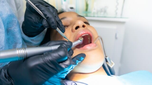 An orthdontist straightening the teeth of a patient