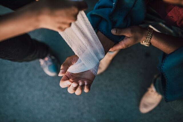 An urgent care center staff treating a patient's wound using a gauze bandage