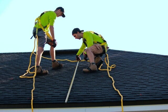 Two men from a roofing company fixing roof problems