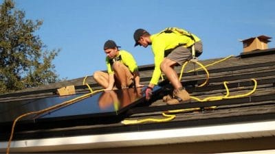 Men adding solar panels on the roof