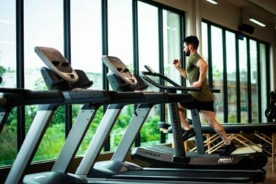 man running on the treadmill using equipment at a fitness gym