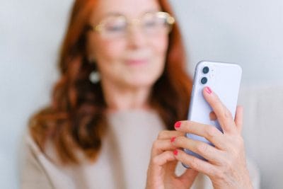 mature woman browsing tiktok for dermatology treatments for skin conditions