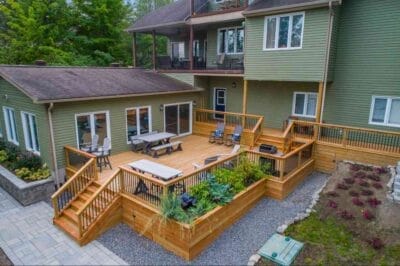 A deck with chairs and tables on it and a deck with plants